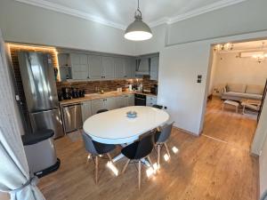 una cucina e una sala da pranzo con tavolo e sedie di Living Life Apartment Komotini a Komotini