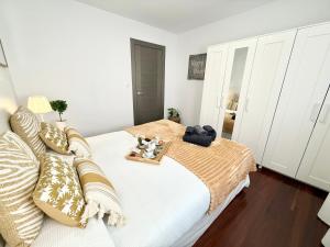 a white bedroom with a bed with a tray of food on it at Castro Holidays - Céntrico Piscina Urbanización Garaje Gratis in Castro-Urdiales +60 photos
