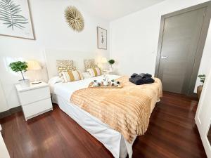 a bedroom with a large bed with a wooden floor at Castro Holidays - Céntrico Piscina Urbanización Garaje Gratis in Castro-Urdiales