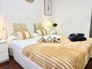 a bedroom with a bed with a tray of towels on it at Castro Holidays - Céntrico Piscina Urbanización Garaje Gratis in Castro-Urdiales