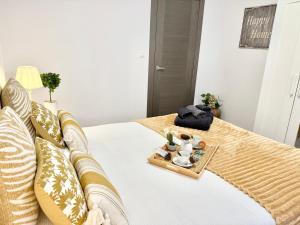 a bedroom with a bed with a tray of food on it at Castro Holidays - Céntrico Piscina Urbanización Garaje Gratis in Castro-Urdiales