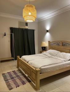 a bedroom with a large bed with a green curtain at Villa Al Haneen in Makkah