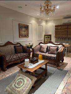 a living room with two couches and a coffee table at Villa Al Haneen in Makkah