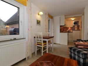 a living room with a table and a kitchen at Ferienwohnung in Wyk-Boldixum auf Foehr in Boldixum +3 photos
