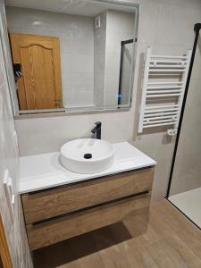a bathroom with a white sink and a mirror at Duplex Torre Almadrava in Denia