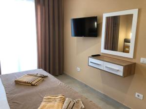 a bedroom with a bed and a mirror and a television at Fabio Apartment Qerret in Golem