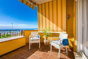 a balcony with two chairs and a view of the ocean at Hermitage Homes RPLA in Puerto de Santiago