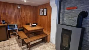 un soggiorno con tavolo e camino di Chalet des Edelweiss, Guzet a Ustou