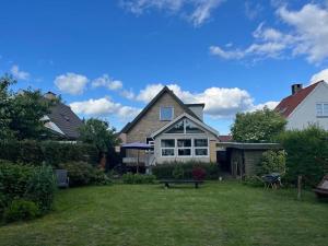 una casa con un patio con un banco en Annes overnatning, en Svendborg