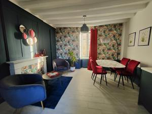 una sala da pranzo con sedie rosse e un tavolo di Les Jardins de l'Orangerie a Durtal
