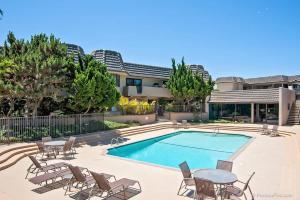 a swimming pool with chairs and a table next to a building at Ocean Infinity - DMBC727B in Solana Beach