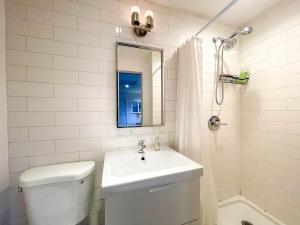 une salle de bain avec un lavabo, des toilettes et un miroir dans l'établissement Private Guesthouse North Sandpoint, à Seattle 3 autres photos