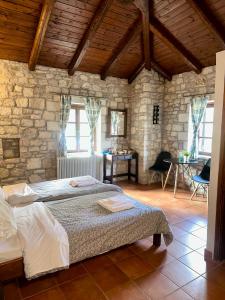 a bedroom with a bed and a stone wall at Saint George Apartments I & IV in Kalavrita