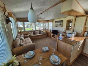 a living room with a couch and a table at 24 The Beeches Caravan Park in Gilcrux