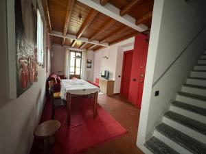 ein Esszimmer mit einem Tisch und einer roten Tür in der Unterkunft Casa Vacanza Castagna in Nesso