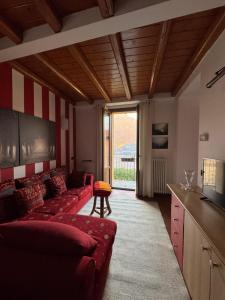 ein Wohnzimmer mit roten Sofas und einem großen Fenster in der Unterkunft Casa Vacanza Castagna in Nesso