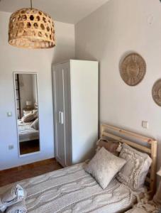 Un dormitorio con una cama y un espejo grande. en Castellano Apartments, en Afantou