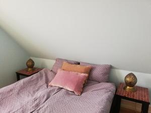 a bed with a pink pillow and two side tables at Villa Ferie og Overnatning in Svendborg +8 photos