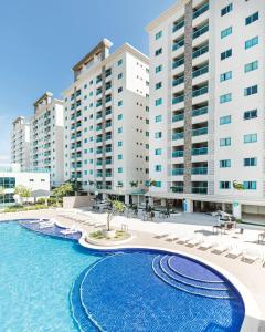 een zwembad met stoelen en een aantal gebouwen bij Resort Varanda Salinas Park in Salinópolis