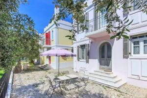 Un patio con una mesa y sillas frente a un edificio. en Villas Thassos, en Limenaria
