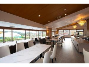 TōganeUE GARDEN RESORT - Vacation STAY 38237v的有白色桌椅和窗户的餐厅