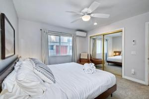 a bedroom with a white bed with a ceiling fan at 3080 Lincoln - Unit 12 in Carlsbad