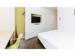 a bedroom with a bed and a desk and a tv at The OneFive Sendai - Vacation STAY 35241v in Sendai