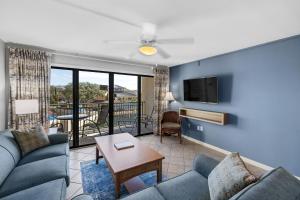 a living room with a couch and a tv at Ocean View at Island Club in Hilton Head Island