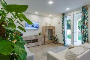 シラクーサにあるVilla Mediterraneaのソファとテレビのあるリビングルーム