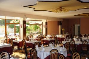 ヴィッラッジョ・モセにあるHotel Tre Torriの白いテーブルと椅子、シャンデリアのあるレストラン