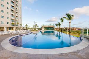 een groot zwembad met stoelen en palmbomen bij Resort Varanda Salinas Park in Salinópolis +22 foto's