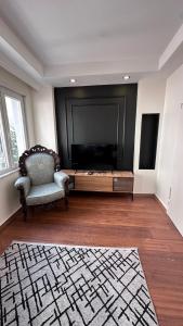 イスタンブールにあるGolden Wood Suitesの薄型テレビと椅子のあるリビングルーム