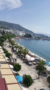 a beach with umbrellas and palm trees next to the water at Artemis Hotel in Bodrum City
