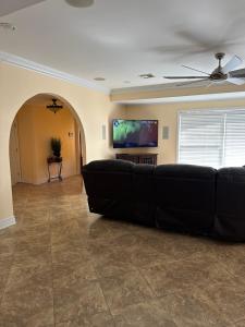 a living room with a black couch and a flat screen tv at New Orleans Ponderosa in New Orleans