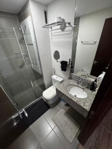 a bathroom with a toilet and a sink and a shower at Suíte Master Rio de Janeiro Próximo ao Rio Centro 9 Andar! in Rio de Janeiro +19 photos