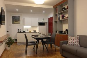 a kitchen and living room with a table and chairs at La Basilica Luxury Apartment - Close to the City Center and Fiera di Vicenza in Vicenza