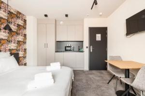 a bedroom with a bed and a table and a kitchen at Casa Española in Ath
