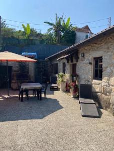 a patio with a table and an umbrella at CASA CON FINCA PRIVADA in Moaña