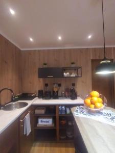 a kitchen with a sink and a bowl of fruit on a counter at Casa das Laranjeiras in Pinhão