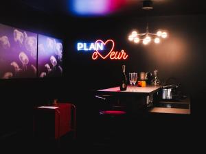a dark room with a bar with a table and a neon sign at PLAN COEUR Romantic Experience & Spa in Riom +19 photos
