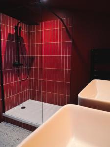 a red tiled bathroom with a tub and a sink at PLAN COEUR Romantic Experience & Spa in Riom