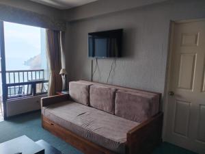 a living room with a couch and a television at Sky View Atitlán Lake Suites - Free Breakfast Supplies in Panajachel