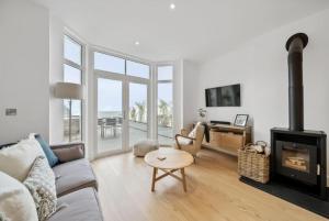 a living room with a couch and a fireplace at Harbour Edge, Luxury 2 BR 2 BA Apt, Sea View and Terrace, Parking in Lynmouth +19 photos