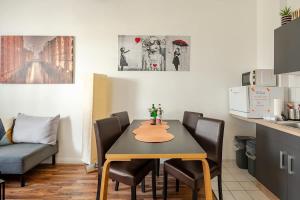 a dining room with a table and chairs and a kitchen at LOFT Fischkopf 3p NDR UKE ZOO in Hamburg