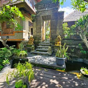 a garden with stairs and a pond in front of a building at Villa Djojonagoro in Ketewel