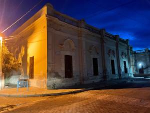 an old building on a street at night at Colegio de María in Cafayate