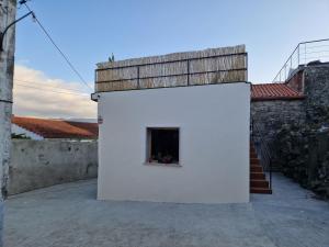 un edificio blanco con una ventana en el costado en Casa Cosmeiro, en Sierra de Outes
