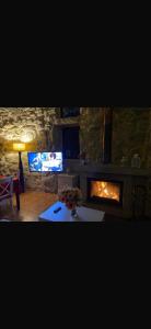 a living room with a fireplace and a tv at CASA CON FINCA PRIVADA in Moaña