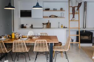 a dining room with a wooden table and chairs at Casa Calmar in Porto Covo