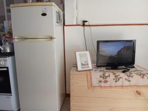 a refrigerator and a television on a wooden desk at Apartamento en Carmelo con piscina in Carmelo +4 photos